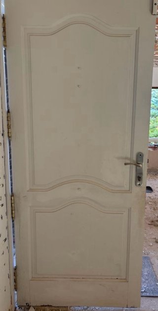 Puerta blanca con aldaba y pomo dorado