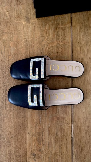 Mules Gucci negras con G de cristal
