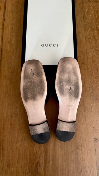 Mules Gucci negras con G de cristal