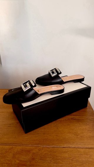 Mules Gucci negras con G de cristal