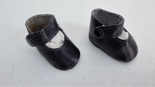 Zapatos de muñeca negros y marrones