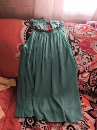 Vestido verde con cadena dorada.