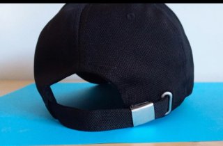 Cappello nero con patch dito medio rosso