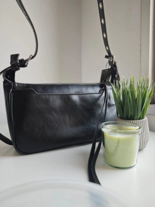 Bolso negro con detalle metálico