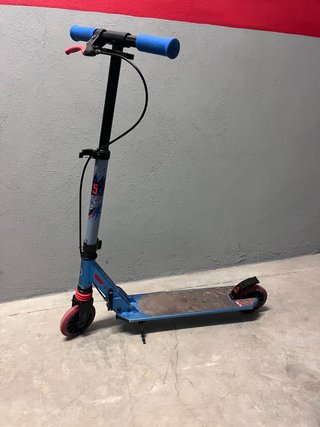 Monopatín azul con ruedas rojas
