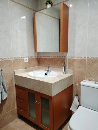 Mueble de baño con lavabo, encimera y grifería.