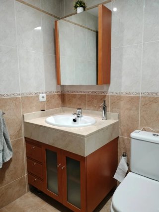 Mueble de baño con lavabo, encimera y grifería.