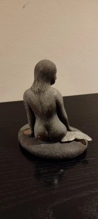 Figura de sirena sentada en roca