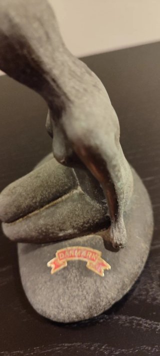 Figura de sirena sentada en roca