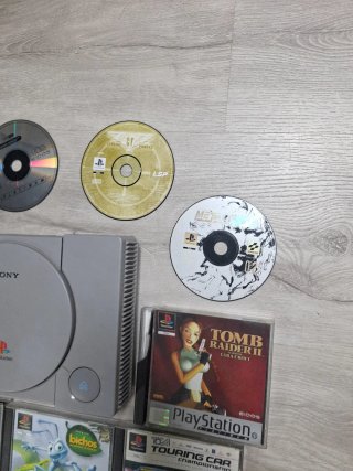 Console PS1 grigia con cavi e giochi
