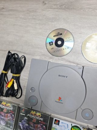Console PS1 grigia con cavi e giochi
