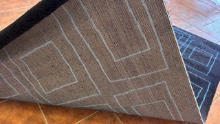 Alfombra negra con diseño geométrico azul