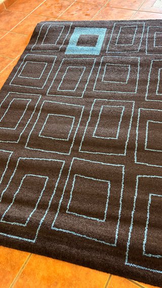 Alfombra negra con diseño geométrico azul