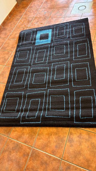 Alfombra negra con diseño geométrico azul