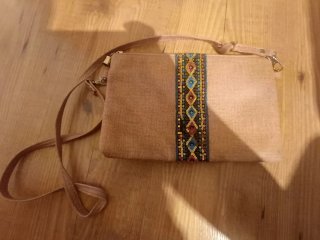 Bolso de mano beige con detalles étnicos
