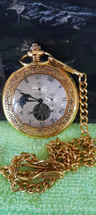 Reloj de bolsillo dorado con cadena