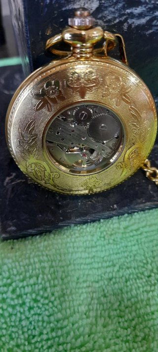 Reloj de bolsillo dorado con cadena