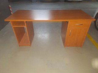 Escritorio de madera con cajón y puertas.