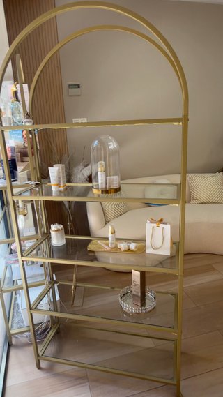Estantería dorada con baldas de cristal
