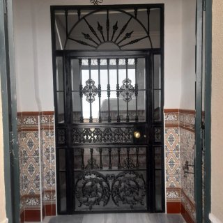 Puerta de hierro forjado con cristal.