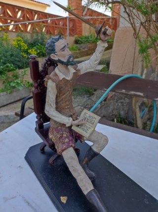 Figura Don Quijote sentado con libro y espada