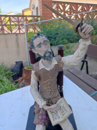 Figura Don Quijote sentado con libro y espada