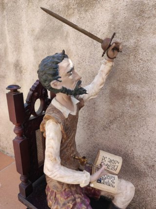 Figura Don Quijote sentado con libro y espada