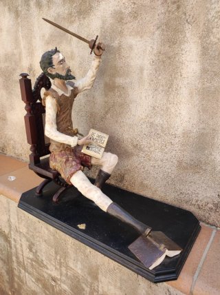 Figura Don Quijote sentado con libro y espada