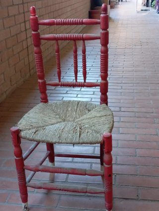 Silla antigua roja con asiento de esparto