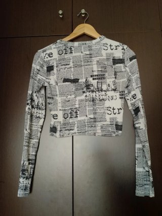 Top manga larga estampado periódico
