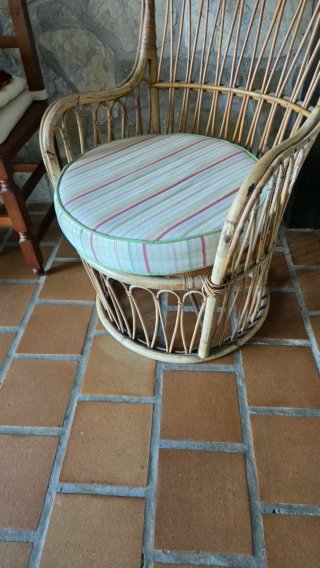 Sillón de mimbre con cojín a rayas
