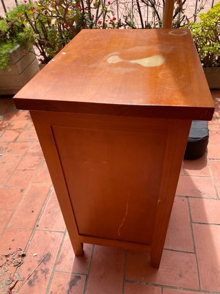Mesita de noche antigua de madera con cajones.