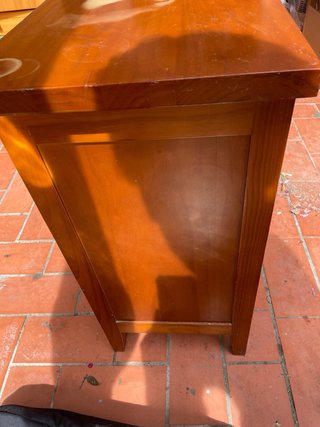 Mesita de noche antigua de madera con cajones.