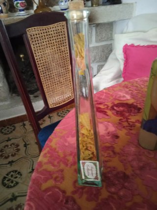 Botella decorativa de vidrio con hojas secas