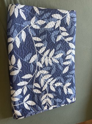 Colcha azul y blanca con hojas