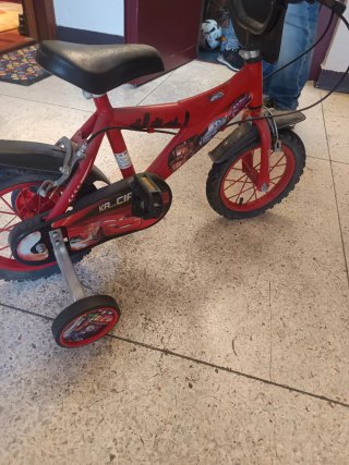 Bicicleta infantil roja con ruedines