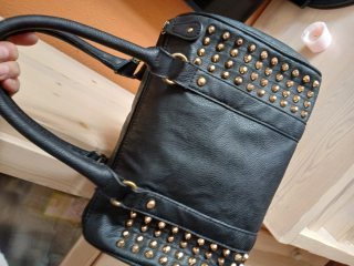 Bolso negro con tachuelas doradas