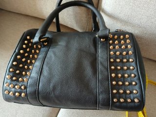 Bolso negro con tachuelas doradas
