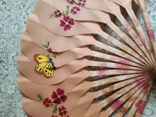 Abanico decorativo rosa con flores y mariposa