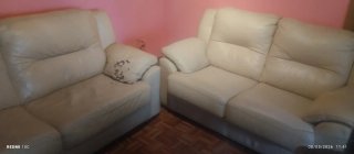 Sofá de piel beige uno está picado y el otro está