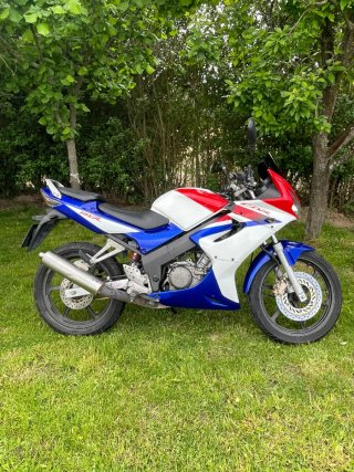 Honda CBR 125R sportbike azul, roja y blanca