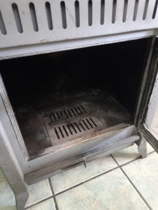 Estufa de leña metálica con puerta de cristal
