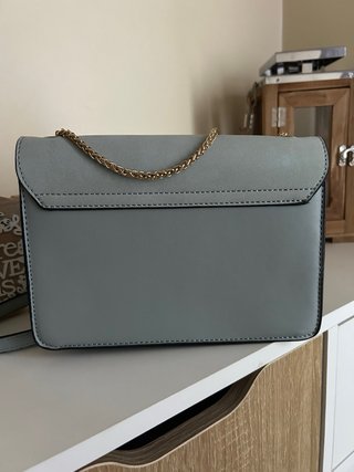 Bolso gris con cadena dorada