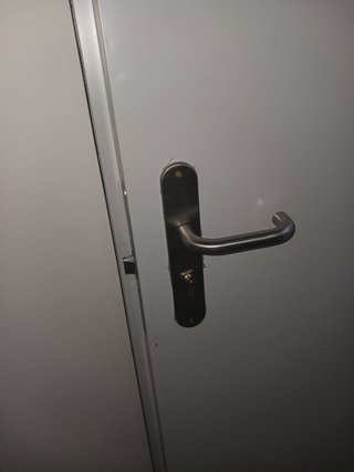 Puerta cortafuegos metal con manillar y cerradura.