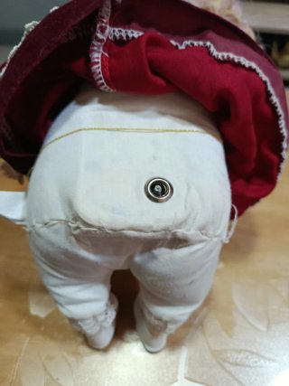 Muñeca de porcelana antigua con sillón de mimbre