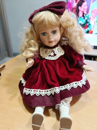 Muñeca de porcelana antigua con sillón de mimbre