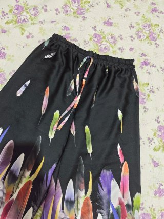 Pantaloni neri con piume colorate