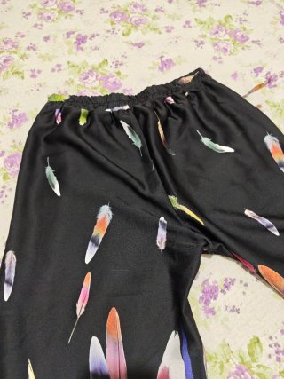 Pantaloni neri con piume colorate