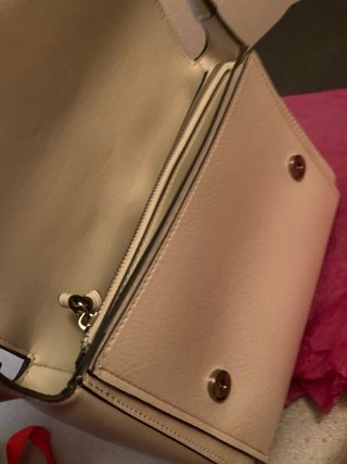 Bolso de mano beige con detalles plateados