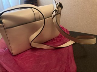 Bolso de mano beige con detalles plateados